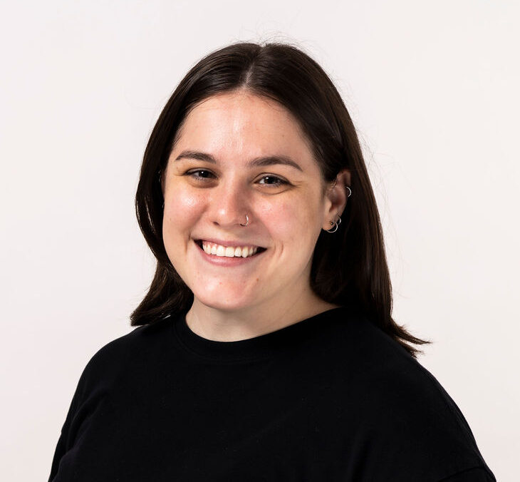 mental health therapist jocelyn kosik with dark shoulder-length hair wearing a black crew-neck sweater smiles in a professional headshot