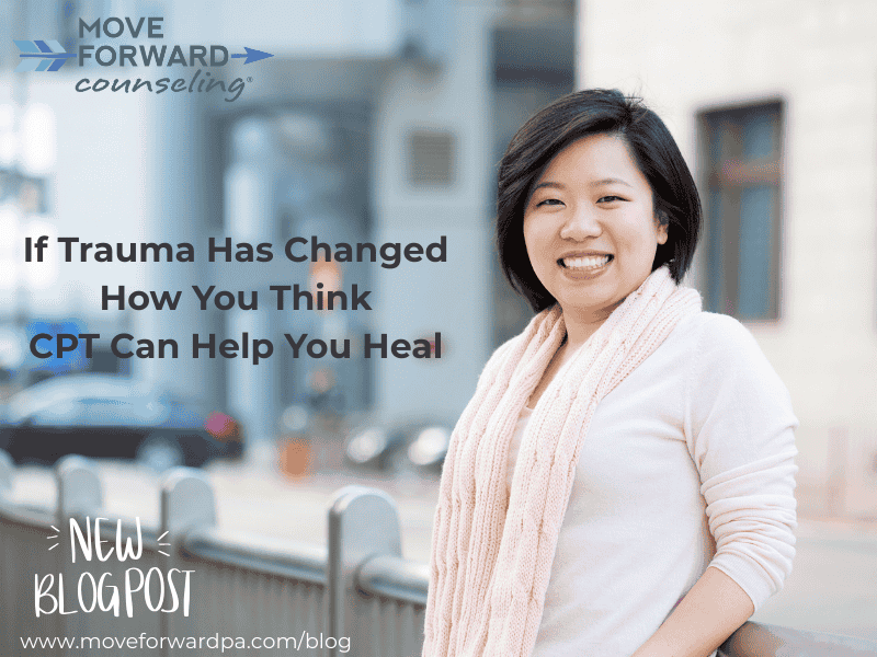 An Asian woman wearing a pink scarf and blouse standing outside on a balcony smiling in the sunshine reflecting on how CPT therapy can help heal trauma