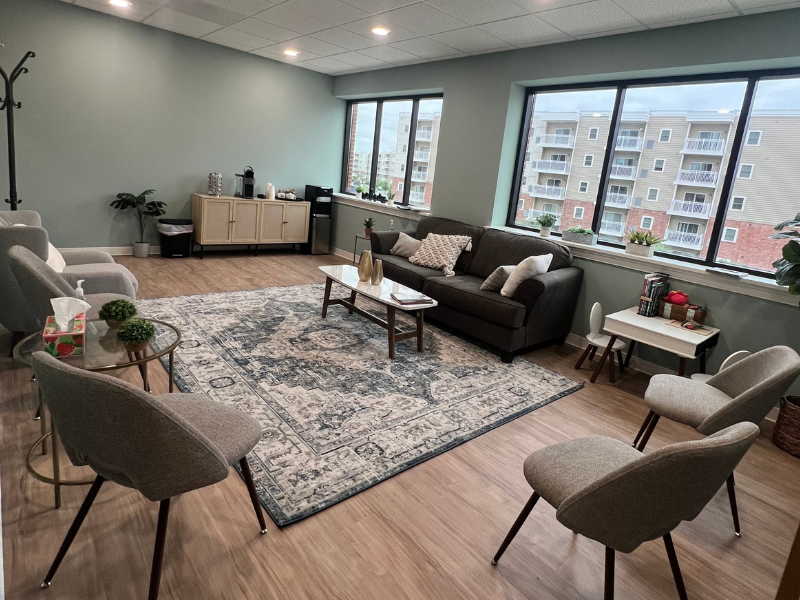 MFC Lebanon therapy office waiting area with couches, chairs, refreshments, and coffee tables in a brightly lit windowed room